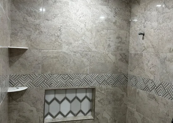 Finished tile shower surround with mosaic accent band in a Houston bathroom remodel